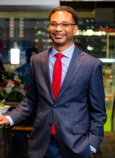 A smiling man in a suit and tie.