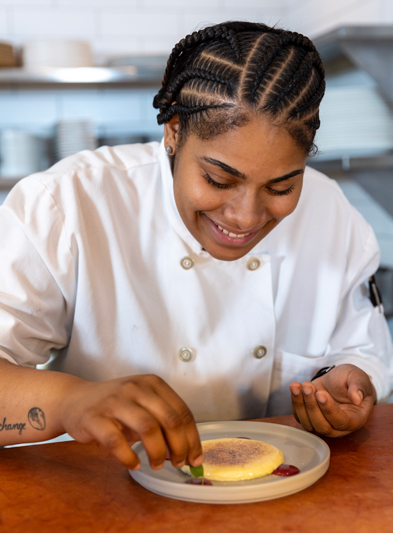 Chef decorating a plate at Patina 250