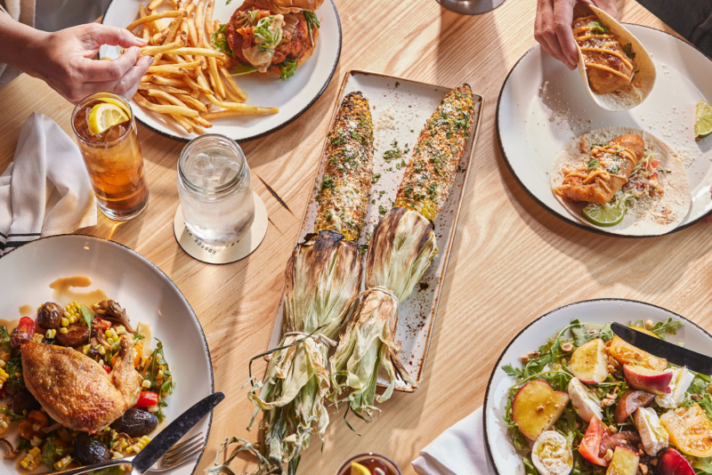 A table topped with plates of food and drinks from Patina catering.