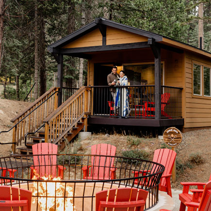 A couple standing on the porch of the Explorer Cabins at Tenaya