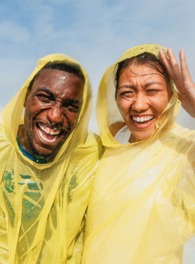 A smiling couple wearing yellow rain jackets at Niagara Falls.